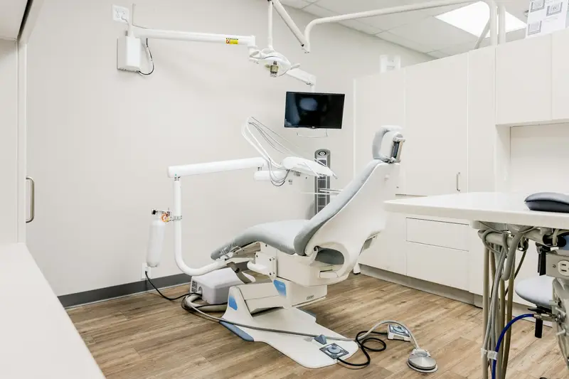 Sala de atendimento odontológico com a cadeira e o equipo.