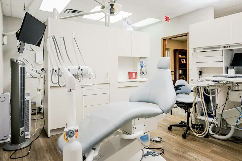 Consultório odontológico claro, com a cadeira vazia.