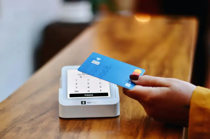 Cartão encostado na maquininha, pagamento por aproximação.